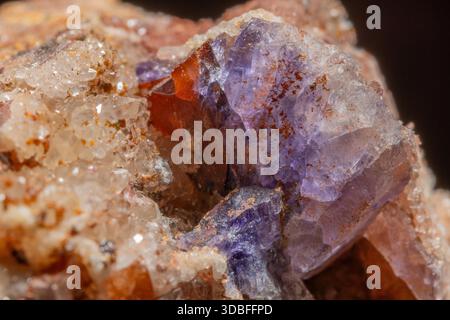 Diese Szene zeigt ein großes Gesteinsfragment mit Quarz- und Fluoritkristallen. Reflexionen und Farben von Mineralien erregen Aufmerksamkeit in der natürlichen Umgebung. Stockfoto