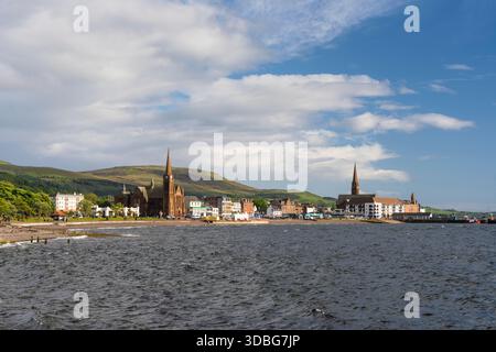 Hafenstadt Largs, Schottland, mit Kirchtürmen aus roten Backsteinen und sanften Hügeln dahinter. Stockfoto