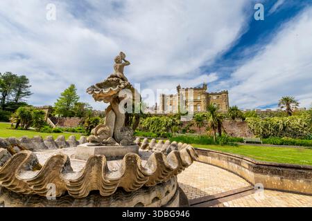 Reich geschmückter Brunnen und Statue mit Blick auf üppige Gärten, während Culzean Castle über die Mauern hinausragt. Stockfoto