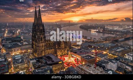 Weihnachtsmarkt am Kölner Dom auf dem Roncalliplatz bei Sonnenuntergang - Feiertage in Deutschland Stockfoto