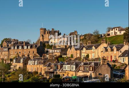 Klassische Selkirk Wohnszene mit Steinhäusern, Burgturm und blauem Himmel über bezaubernden Dächern des Dorfes. Stockfoto