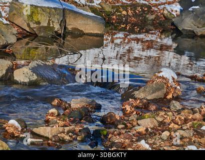 Ein langer Blick auf den Wolf Creek, einen fließenden Bach mit kleinen Wasserfällen und einem gläsernen Wasserbecken. In Ridgefield, New Jersey, USA. Stockfoto