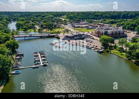 Blick aus der Vogelperspektive auf die Innenstadt von Algonquin Illinois entlang des Fox River mit Straßenlandschaften am Flussufer, Brückenüberquerung, Yachthafen und lokalen Unternehmen. Stockfoto