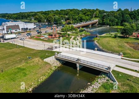 Blick aus der Vogelperspektive auf die Innenstadt von Algonquin Illinois entlang des Fox River mit Straßenlandschaften am Flussufer, Brückenüberquerung, Yachthafen und lokalen Unternehmen. Stockfoto
