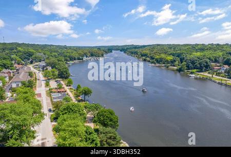 Blick aus der Vogelperspektive auf die Innenstadt von Algonquin Illinois entlang des Fox River mit Straßenlandschaften am Flussufer, Brückenüberquerung, Yachthafen und lokalen Unternehmen. Stockfoto