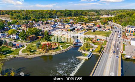 Blick aus der Vogelperspektive auf die Innenstadt von Algonquin Illinois entlang des Fox River mit Straßenlandschaften am Flussufer, Brückenüberquerung, Yachthafen und lokalen Unternehmen. Stockfoto