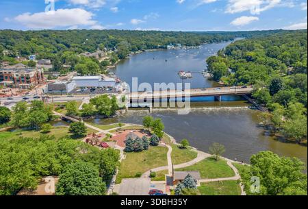 Blick aus der Vogelperspektive auf die Innenstadt von Algonquin Illinois entlang des Fox River mit Straßenlandschaften am Flussufer, Brückenüberquerung, Yachthafen und lokalen Unternehmen. Stockfoto