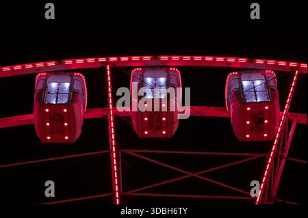 Riesenradkabinen, die nachts während des Weihnachtsmarktes im Stadtzentrum beleuchtet werden. Stockfoto