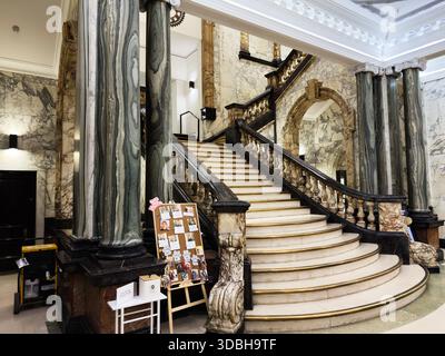 Manchester, Großbritannien - 20. November 2025: Eine majestätische Marmortreppe und Marmorsäulen in einem großen Innenraum der Universität Manchester mit klassischem Archi Stockfoto
