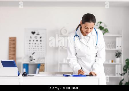 Junge Ärztin schreibt Rezept in der Klinik Stockfoto