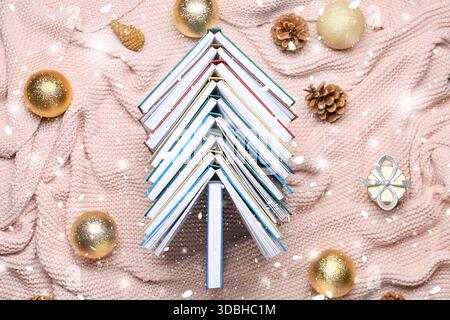 Viele Bücher und Weihnachtsdekorationen auf gestricktem Karo Stockfoto