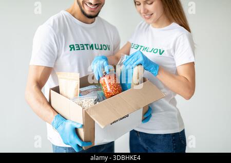 Junge Freiwillige versammeln während der Quarantäne Lebensmittelspenden für humanitäre Hilfe Stockfoto