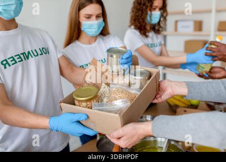 Junge Freiwillige verpacken Lebensmittelspenden für Familien in Not bei der Community Charity Event Stockfoto