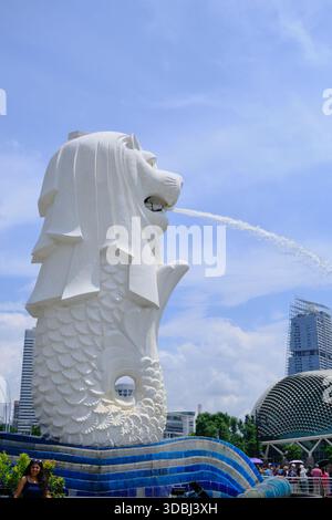 Eine ikonische vertikale Aufnahme der Merlion-Statue, Singapurs nationale Personifikation und Wahrzeichen, die Wasser vor einem hellblauen Himmel sprüht. Stockfoto