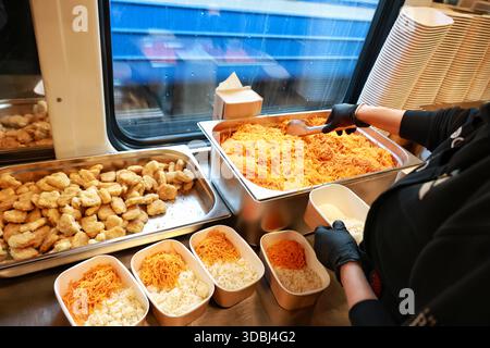 Ein Freiwilliger des Food Train, der Menschen ohne Strom und Heizung wegen eines russischen Angriffs warme Mahlzeiten liefert, packt am 16. Dezember 2025 in Odesa (Ukraine) Mittagspause (Foto: Nina Liashonok/Ukrinform) Stockfoto