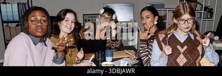 Verschiedene Gruppen von Personen posieren spielerisch während des Creative Team Meetings Stockfoto