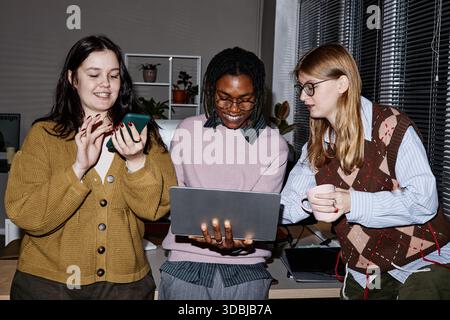 Multiethnische junge Erwachsene Menschen, die im modernen Büro zusammenarbeiten und lächeln Stockfoto
