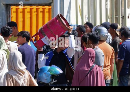 Banda Aceh, Aceh, Indonesien. Dezember 2025. Anwohner transportieren am 17. Dezember 2025 nichtsubventioniertes LPG-Gas bei einer Agentur in Banda Aceh, Provinz Aceh, Indonesien. Nach der Katastrophe haben mehrere Brückeneinbrüche die Verteilung von Flüssiggas unterbrochen, was zu tagelangen Warteschlangen führte. Die Behörden haben alle Transportmittel eingesetzt, um eine kontinuierliche Versorgung mit LPG und anderen wichtigen Hilfsmitteln in den von Überschwemmungen und Erdrutschen betroffenen Gebieten Sumatra, Indonesien, sicherzustellen. (Kreditbild: © Khairu Syukrillah/ZUMA Press Wire) NUR REDAKTIONELLE VERWENDUNG! Nicht für kommerzielle ZWECKE! Stockfoto