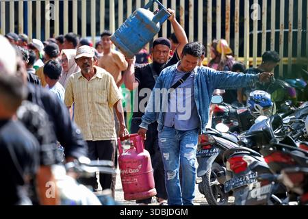 Banda Aceh, Aceh, Indonesien. Dezember 2025. Anwohner transportieren am 17. Dezember 2025 nichtsubventioniertes LPG-Gas bei einer Agentur in Banda Aceh, Provinz Aceh, Indonesien. Nach der Katastrophe haben mehrere Brückeneinbrüche die Verteilung von Flüssiggas unterbrochen, was zu tagelangen Warteschlangen führte. Die Behörden haben alle Transportmittel eingesetzt, um eine kontinuierliche Versorgung mit LPG und anderen wichtigen Hilfsmitteln in den von Überschwemmungen und Erdrutschen betroffenen Gebieten Sumatra, Indonesien, sicherzustellen. (Kreditbild: © Khairu Syukrillah/ZUMA Press Wire) NUR REDAKTIONELLE VERWENDUNG! Nicht für kommerzielle ZWECKE! Stockfoto