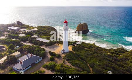 Blick aus der Vogelperspektive auf den berühmten weißen Split Point Lighthouse mit seiner markanten roten Spitze, die hoch über dem türkisfarbenen Meer und der zerklüfteten Küste steht, Split P Stockfoto