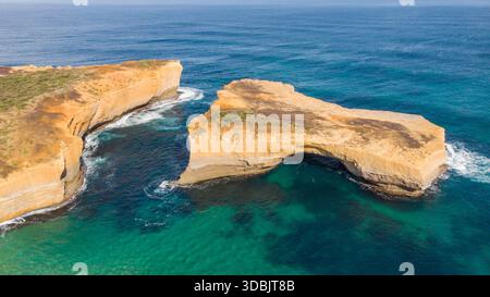 Aus der Vogelperspektive auf die berühmte Felsformation der London Bridge, die trotzig vor dem türkisfarbenen Wasser der Great Ocean Road steht, London Bridge, Victoria, Stockfoto