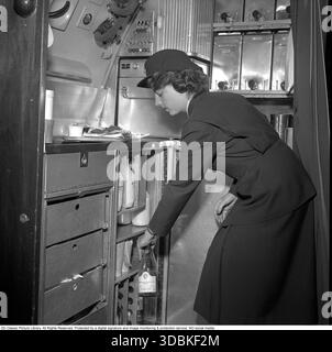 Flugreisen in den 1950er Jahren Weibliches Flugbesatzungsmitglied bereitet sich darauf vor, den Passagieren in einem SAS-Geschäftsflugzeug 1951 Kaffee und Sandwiches zu servieren. Conard Ref. 1854 Stockfoto