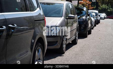 Geparkte Autos am Straßenrand gegen das Licht Stockfoto
