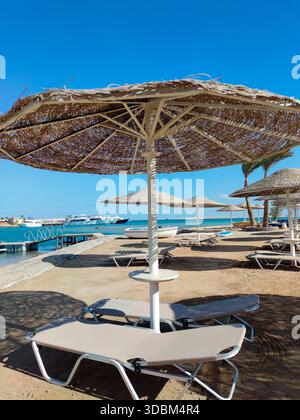 Leere Liegestühle und Sonnenschirme am Strand, Ägypten Stockfoto