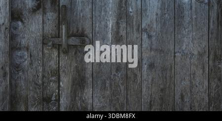 Hintergrundstruktur alter grauer Holzdielen. Rustikales Holztor mit Verriegelung zum Öffnen. Stockfoto
