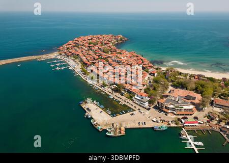 Aus der Vogelperspektive des antiken Sozopols sehen Sie Terrakotta-Dächer, die in türkisfarbenes Wasser kaskadieren, im Kontrast zu den Sandstränden in Sozopol, Bulgarien. Stockfoto