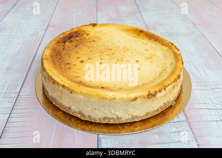 Veganer Käsekuchen aus Cashewkernen und Seidentofu, mit Datteln und Walnusskruste, dekoriert mit frischen Beeren und Kokosraspeln Stockfoto