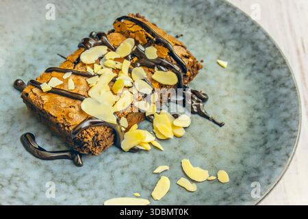 Dreifache Schokoladen-Brownie mit Stückchen weißer, Milch und dunkler Schokolade, gebacken zu einer kausüßen Textur und mit Meersalz bestreut Stockfoto