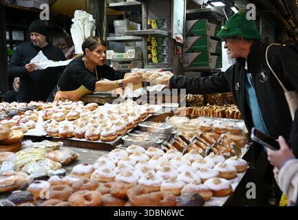 Jerusalem, Israel. Dezember 2025. Ein Bäcker verkauft am vierten Tag des achttägigen jüdischen Festivals von Hanukka, dem Festival der Lichter, in Jerusalem am Dienstag, den 17. Dezember 2025, mit Gelee gefüllte Donuts, Sufganiyot. Hanukkah markiert den wundersamen Sieg der Makkabäer, die jüdischen Freiheitskämpfe, den Sieg über die griechischen Besatzer und das Wunder eines Tages Öl, das acht Tage dauerte, bei der Neuweihung des zweiten Tempels in Jerusalem. Foto: Debbie Hill/ Credit: UPI/Alamy Live News Stockfoto