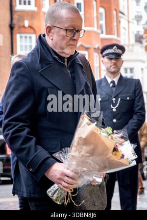 Harrods, Hans Crescent, Knightsbridge, London, Großbritannien. Dezember 2025. Ehemalige Polizeibeamte, Familienmitglieder, die im Dienst des Rettungsdienstes stehen, und Harrods-Mitarbeiter versammeln sich zum 42. Jahrestag des weihnachtlichen Angriffs der IRA auf diesen berühmten Londoner Laden im Jahr 1983. Die versammelten Personen hielten um 13:21 Uhr, der Zeit der Explosion, eine Schweigeminute ab, um an die Toten oder Verletzten zu erinnern. Von den sechs Toten waren drei Metropolitanpolizisten auf der Chelsea Polizeistation, die versuchten, das Gebiet zu evakuieren, als die Bombe explodierte. Quelle: Newspics UK London/Alamy Live News Stockfoto