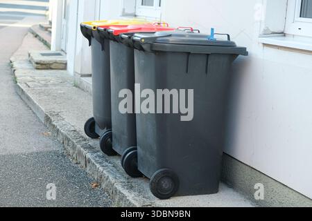 Müllsortierung in Europa. Mülltonnen mit bunten Deckeln für verschiedene Müllarten Stockfoto