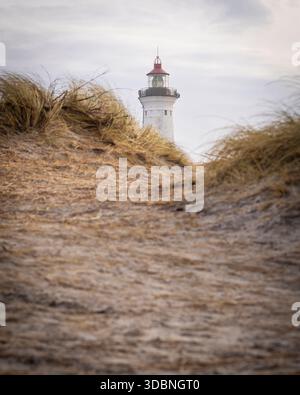 Blick auf die Spitze des Leuchtturms Lynfvig Fyr im Hintergrund am Strand von Hvide Sande in Dänemark. Stockfoto