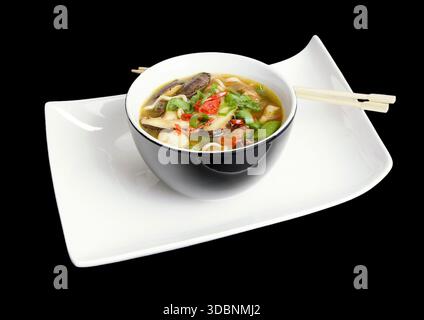 Asiatische Pilzsuppe mit Nudeln und Gemüse in einer modernen Schüssel Stockfoto