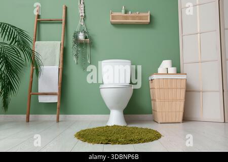 Das Innere des stilvollen Toiletten mit Keramikschale, Papierrollen und Korb Stockfoto