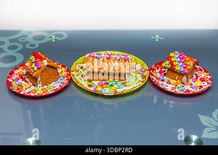 Aus nächster Nähe sehen Sie bunte Lebkuchenhäuser, die mit Süßigkeiten dekoriert sind und als traditionelles Weihnachtsdessert serviert werden. Schweden. Stockfoto