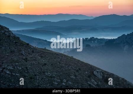 Ein ruhiger Blick von Lukomir kurz vor Sonnenaufgang, mit nebeligen Tälern und überlagerten Hügeln, die im sanften Licht der Dämmerung in die Ferne fallen. Lukomir, Konjic, Kanton Herzegowina-Neretva, Bosnien und Herzegowina Stockfoto
