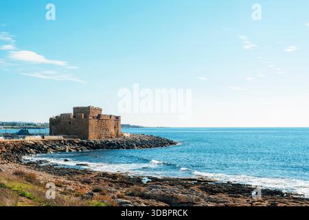 Mittelalterliche Steinburg an felsiger Küste mit Wellen und offenem Meer, historische Festung mit Blick auf das mittelmeer in Zypern. Stockfoto