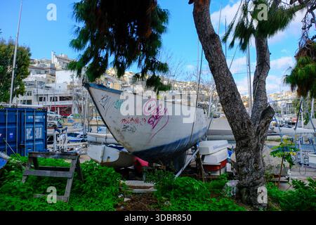 DEZ 09 2025 - Athen, Griechenland - ein altes verrottendes Segelboot, das am Hafen von Pireus, Athen, am Hafen geparkt wurde Stockfoto