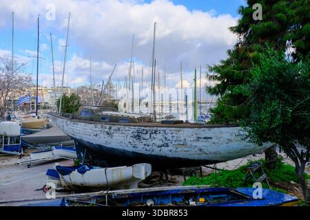 DEZ 09 2025 - Athen, Griechenland - ein altes verrottendes Segelboot, das am Hafen von Pireus, Athen, am Hafen geparkt wurde Stockfoto