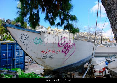 DEZ 09 2025 - Athen, Griechenland - ein altes verrottendes Segelboot, das am Hafen von Pireus, Athen, am Hafen geparkt wurde Stockfoto
