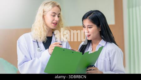 Professionelle Ärzte und Team diskutieren in Klinikhalle, medizinische Fachkräfte diskutieren im Krankenhauskorridor. Stockfoto