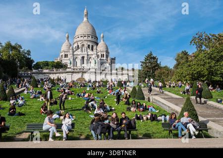 Menschen auf dem Hügel von Montmartre an einem Sonntagnachmittag unter der Basilika Sacre-Coeur, Paris, Frankreich Stockfoto