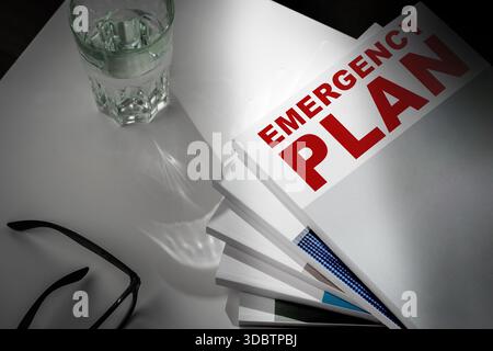 Notfallplan-Dokumente mit Gläsern und Glas Wasser auf einem Tisch Stockfoto
