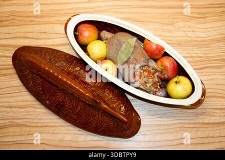 Wildente in Äpfeln in einem Keramikstall mit Lorbeerblatt. Stockfoto