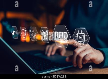 RFID-Technologie und Funkfrequenzidentifizierungskonzept. Person, die einen Laptop mit RFID-Symbolen, drahtlosem Signal, Sicherheitsschild, Checkliste, datenflo verwendet Stockfoto