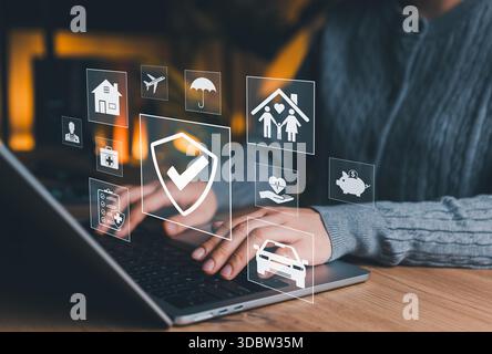 Versicherungskonzept. Person, die Laptop mit Versicherungssymbolen für Gesundheit, Leben, Familie, Reise, Auto, Wohnraum und finanzieller Schutz als Symbol für Sicherheit, Stockfoto